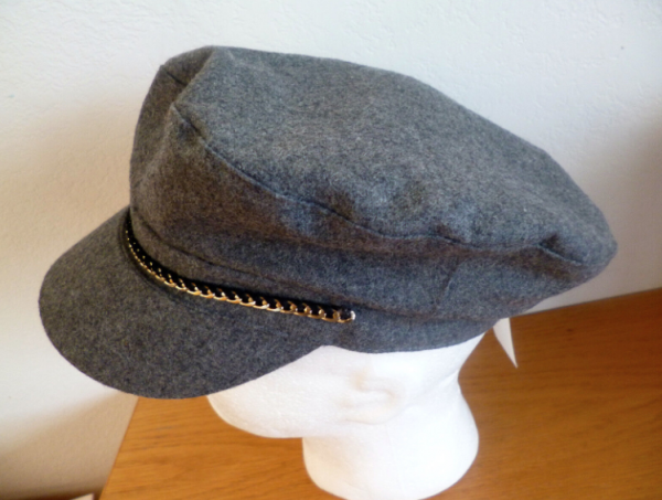 Topi newsboy dengan aksen rantai emas